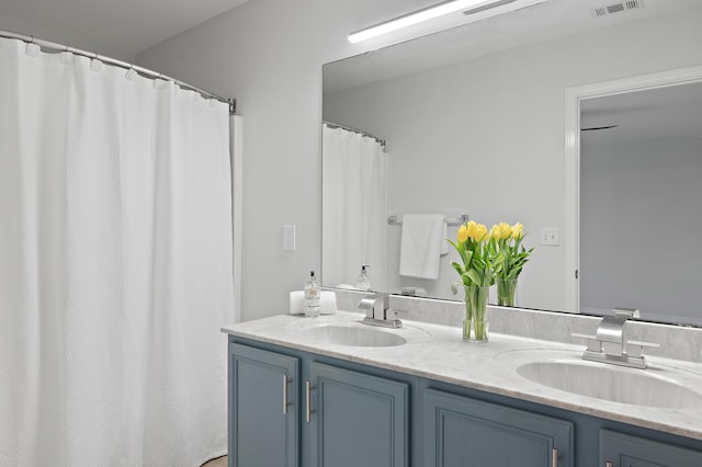 bathroom with visible vents, a sink, and double vanity