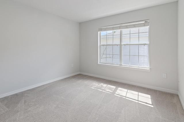 unfurnished room featuring carpet floors and baseboards