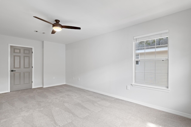 carpeted empty room with visible vents, ceiling fan, and baseboards