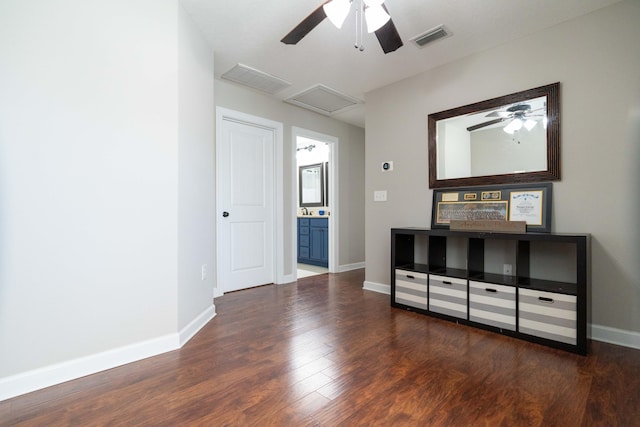 interior space with visible vents, attic access, ceiling fan, wood finished floors, and baseboards