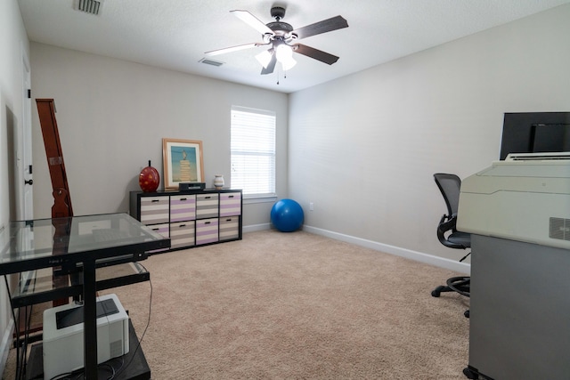 carpeted office with baseboards, visible vents, and ceiling fan