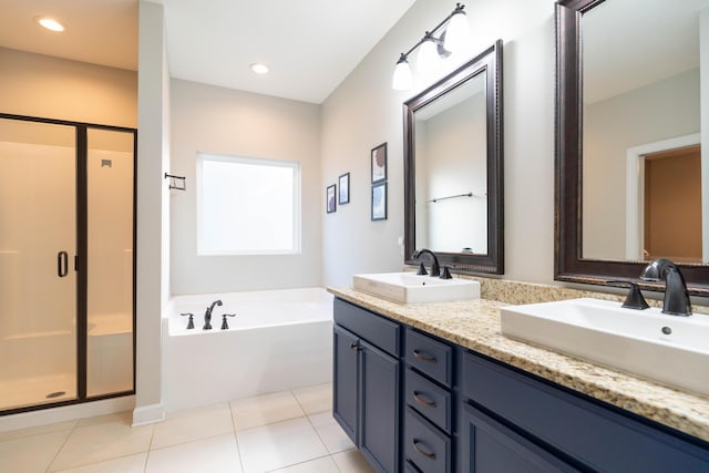 bathroom featuring a garden tub, a stall shower, a sink, and tile patterned floors