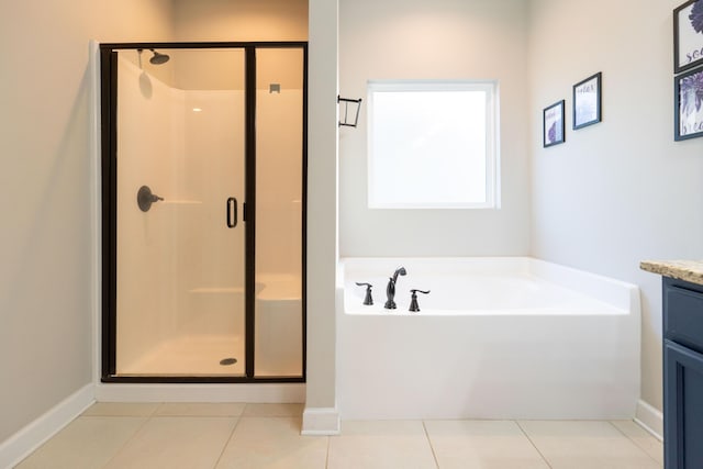 bathroom featuring a stall shower, a garden tub, vanity, and tile patterned floors