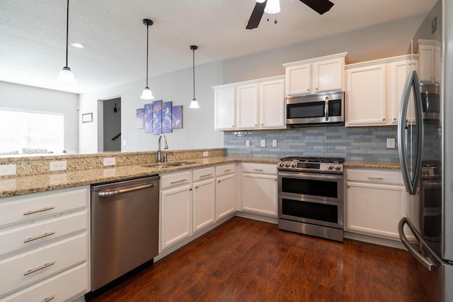 kitchen featuring dark wood finished floors, stainless steel appliances, tasteful backsplash, white cabinetry, and a sink