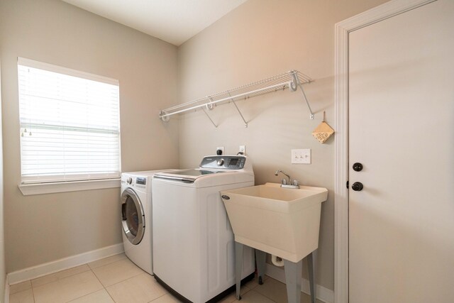 laundry area with laundry area, light tile patterned floors, baseboards, and separate washer and dryer