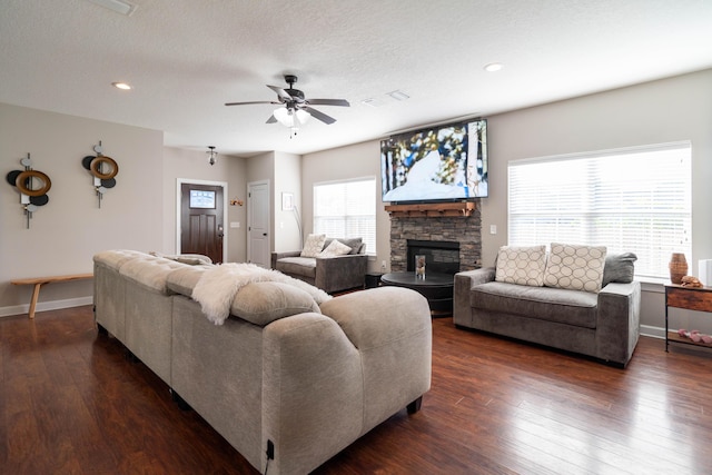 living area with dark wood-style floors, visible vents, a textured ceiling, and baseboards