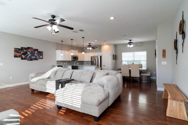 living room featuring recessed lighting, visible vents, dark wood finished floors, and baseboards