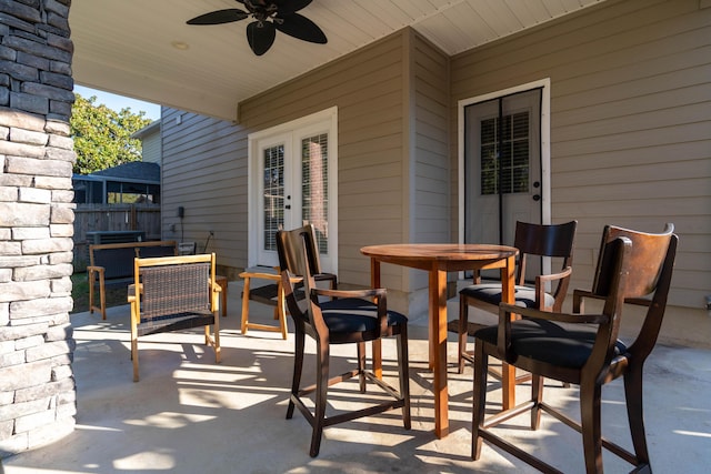 view of patio featuring ceiling fan, french doors, outdoor dining area, and fence