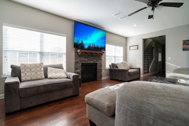 living area featuring baseboards, stairs, visible vents, and wood finished floors