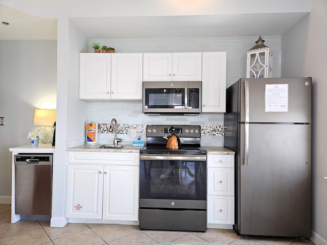 kitchen featuring appliances with stainless steel finishes, white cabinets, and a sink