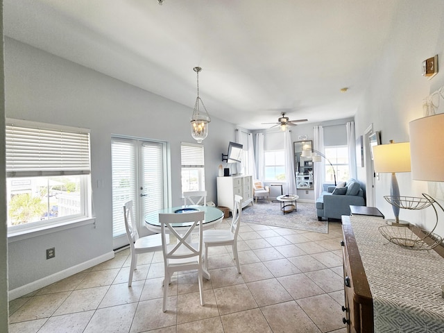 dining room with light tile patterned flooring, baseboards, and ceiling fan with notable chandelier