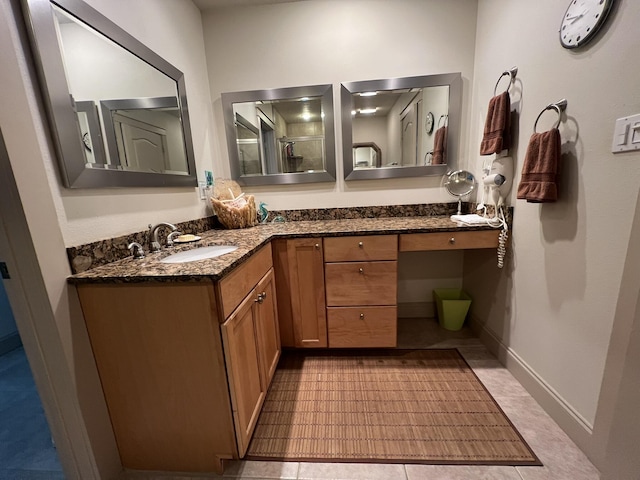 full bath with tile patterned flooring, baseboards, and vanity