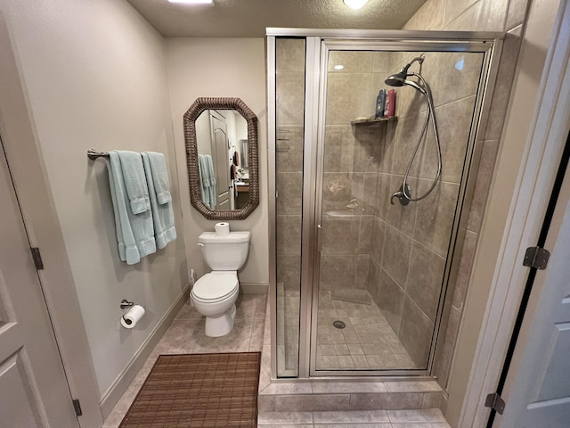 full bathroom with toilet, a shower stall, baseboards, and tile patterned floors