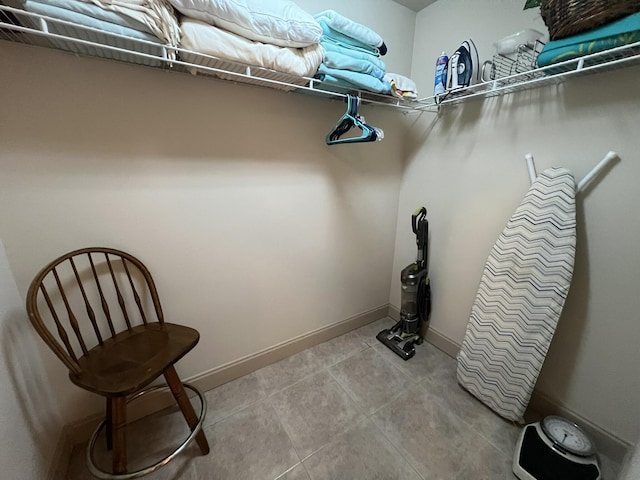 walk in closet with light tile patterned floors