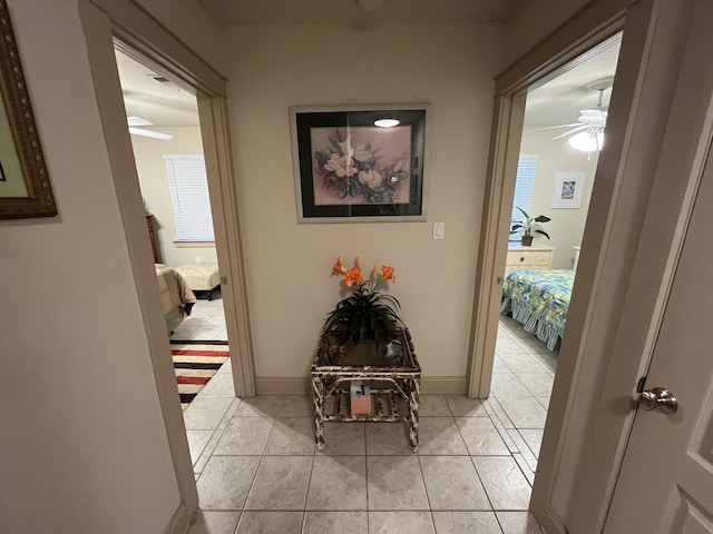 hallway featuring baseboards and light tile patterned floors