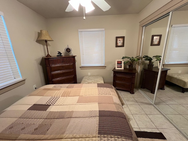 bedroom featuring ceiling fan, light tile patterned floors, and a closet