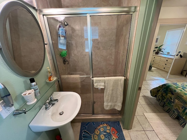 full bathroom featuring a stall shower, tile patterned flooring, and a sink