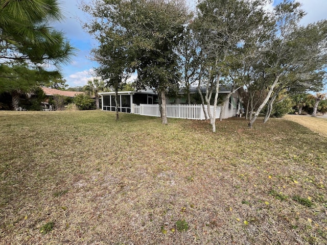 view of yard with a sunroom and fence