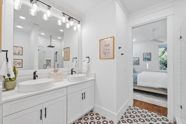 ensuite bathroom with crown molding, ceiling fan, a sink, and a shower stall