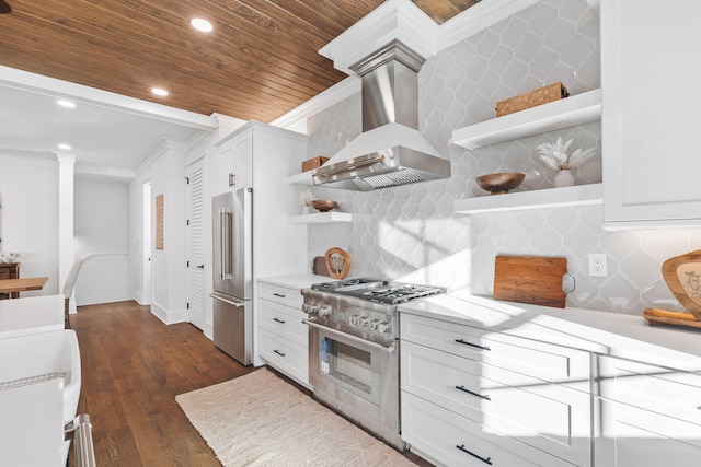 kitchen featuring high end appliances, ornamental molding, light countertops, wall chimney range hood, and open shelves