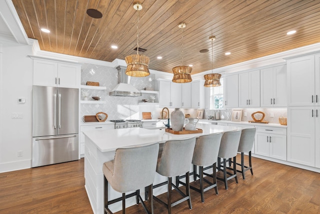 kitchen with high quality fridge, wooden ceiling, wall chimney range hood, open shelves, and an island with sink