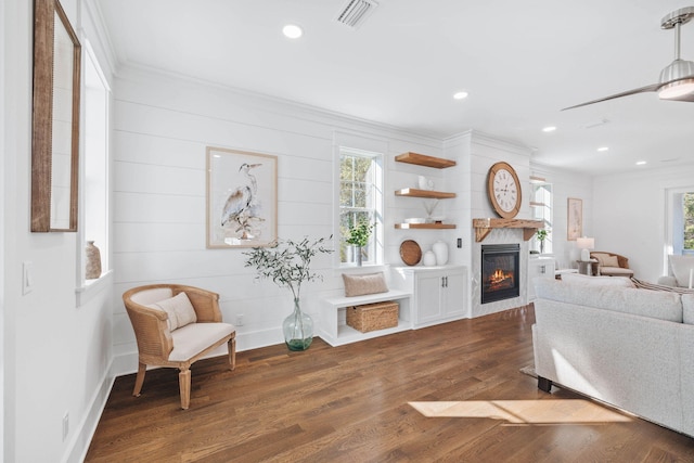 sitting room featuring a healthy amount of sunlight, visible vents, dark wood-style flooring, and ornamental molding