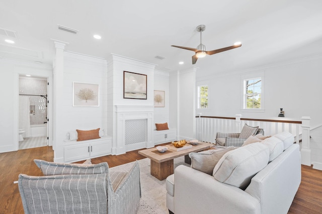 living area featuring ornamental molding, recessed lighting, visible vents, and wood finished floors