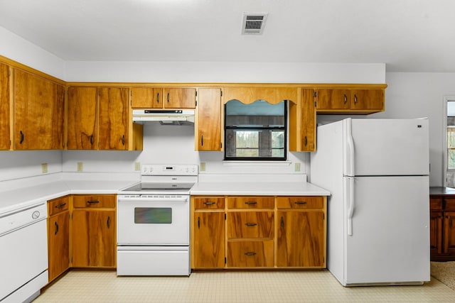 kitchen with light countertops, white appliances, visible vents, and under cabinet range hood