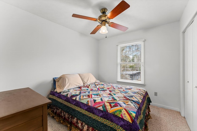 bedroom with a ceiling fan, carpet, a closet, and baseboards