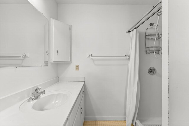 full bathroom featuring baseboards, a shower stall, and vanity