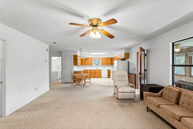 living room with light carpet, plenty of natural light, visible vents, and ceiling fan with notable chandelier