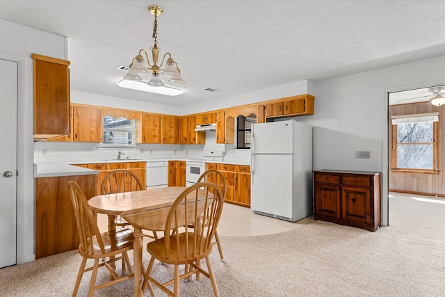 kitchen featuring light countertops, white appliances, plenty of natural light, and light colored carpet