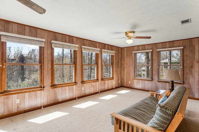 unfurnished sunroom with ceiling fan, plenty of natural light, and visible vents