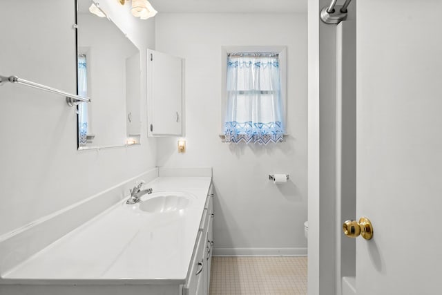 bathroom with toilet, baseboards, and vanity