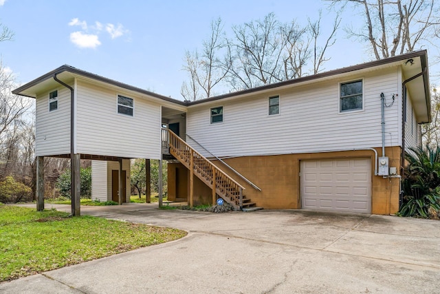 view of front facade with stairs, driveway, and an attached garage