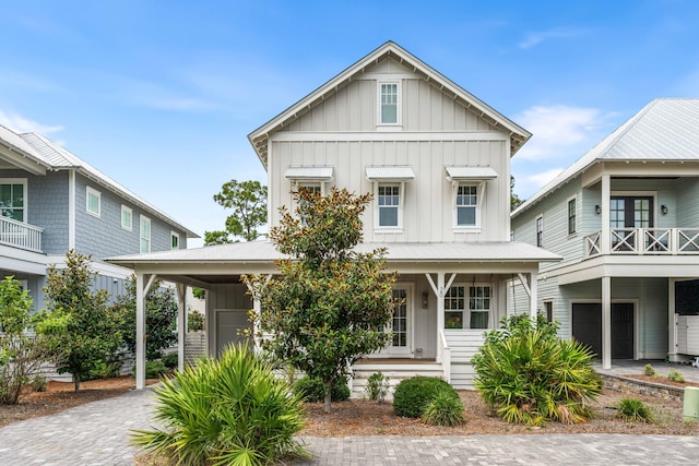 view of front of property featuring a balcony, a garage, decorative driveway, and board and batten siding