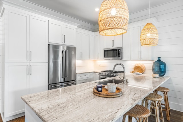 kitchen with a peninsula, light stone countertops, high quality appliances, and a sink