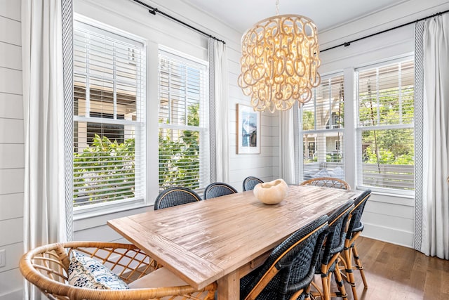 dining room featuring a healthy amount of sunlight, a notable chandelier, and wood finished floors