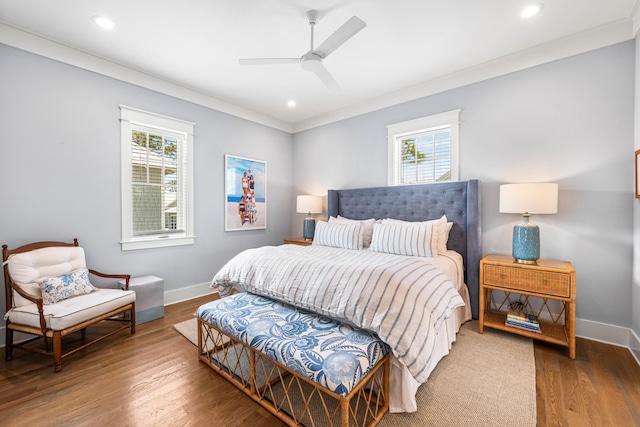 bedroom with multiple windows, baseboards, and wood finished floors