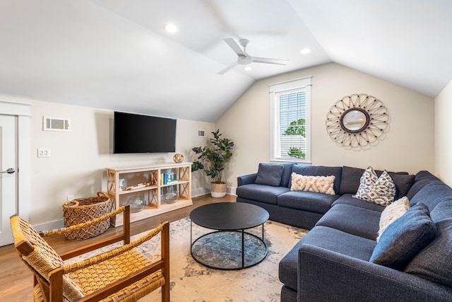 living room with lofted ceiling, wood finished floors, visible vents, and baseboards