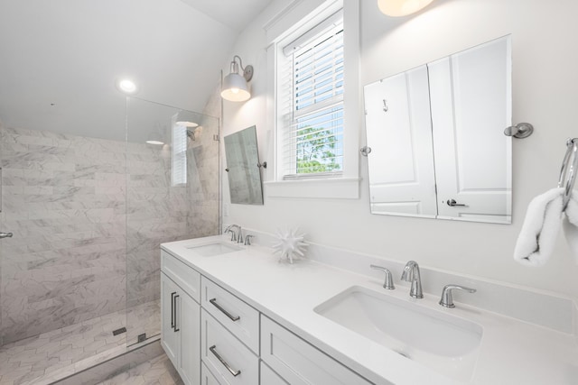 full bathroom with marble finish floor, double vanity, a sink, and a walk in shower