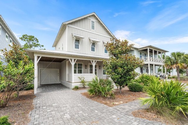 view of front of property with a balcony, decorative driveway, metal roof, and board and batten siding