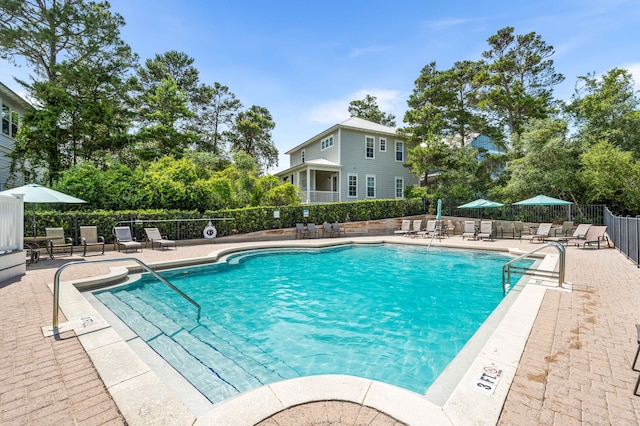 pool with a patio area and fence