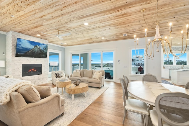 living area with a notable chandelier, recessed lighting, a stone fireplace, light wood-type flooring, and wooden ceiling