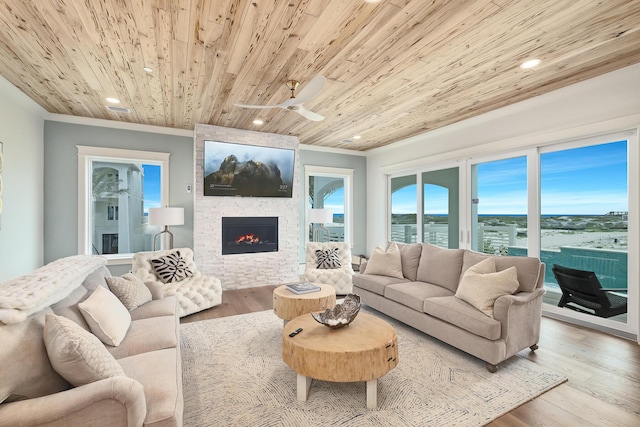 living area with ornamental molding, wood ceiling, and wood finished floors