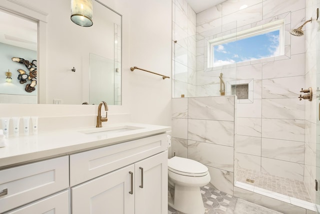 full bathroom with toilet, a tile shower, and vanity