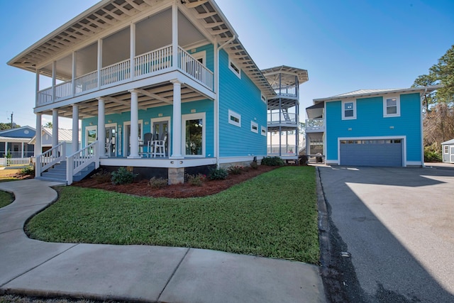 view of front facade with a garage, a balcony, aphalt driveway, a porch, and a front yard