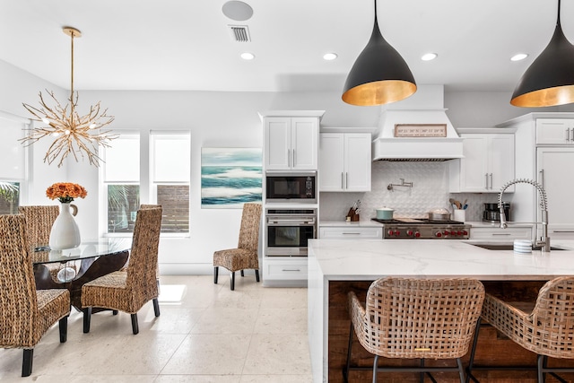 kitchen with built in appliances, a sink, visible vents, tasteful backsplash, and custom range hood