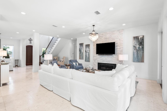 living area with stairs, a stone fireplace, visible vents, and recessed lighting