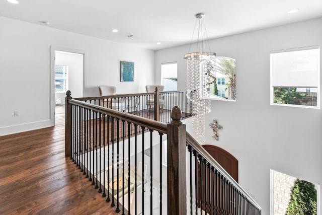 staircase featuring recessed lighting, wood-type flooring, a healthy amount of sunlight, and an inviting chandelier